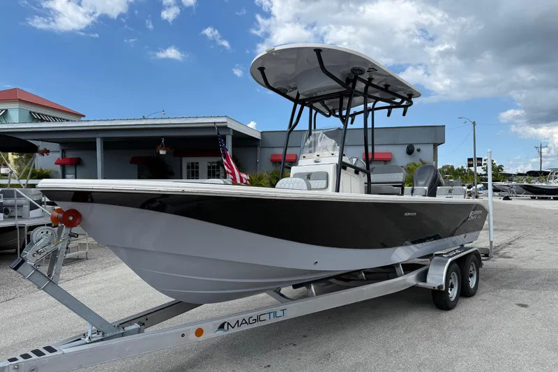 The Image of 2025 Carolina Skiff 24 Ultra Elite boat on trailer, parked outdoors under a cloudy sky. - 0