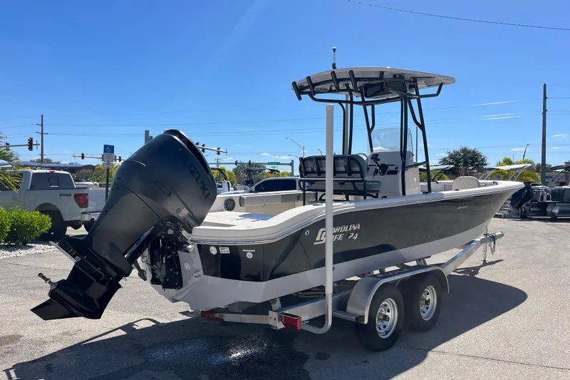 Slide: The Image of 2025 Carolina Skiff 24 Ultra Elite boat on trailer, featuring a powerful outboard motor. - 10