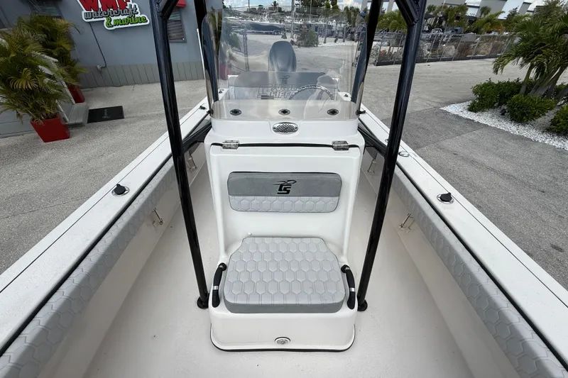 Slide: The Image of 2025 Carolina Skiff 24 Ultra Elite boat interior with seating and console, docked outdoors. - 26