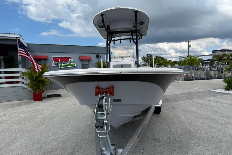 Slide: The Image of 2025 Carolina Skiff 24 Ultra Elite boat on trailer at dealership, cloudy sky background. - 3