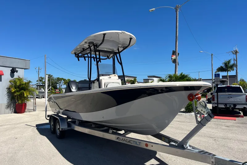 Slide: The Image of 2025 Carolina Skiff 24 Ultra Elite boat on trailer under clear blue sky. - 8