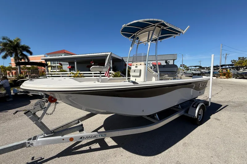The Image of 2025 Carolina Skiff 19 LS boat on trailer, parked outdoors under clear blue sky. - 0