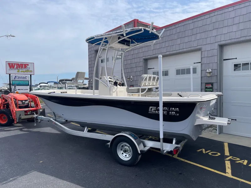 Slide: The Image of 2025 Carolina Skiff 19 LS boat on trailer, parked outdoors under clear blue sky. - 3