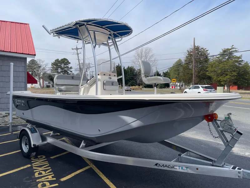 Slide: The Image of 2025 Carolina Skiff 19 LS boat on trailer, parked outdoors under clear blue sky. - 4