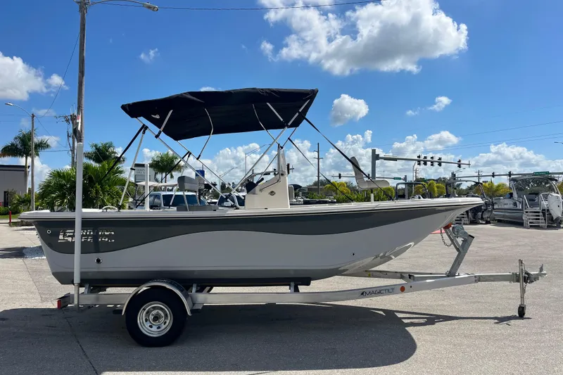 Slide: The Image of 2025 Carolina Skiff 19 LS boat on trailer, parked outdoors under a clear blue sky. - 2