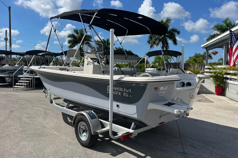 Slide: The Image of 2025 Carolina Skiff 19 LS boat on trailer, sunny day, palm trees in background. - 3
