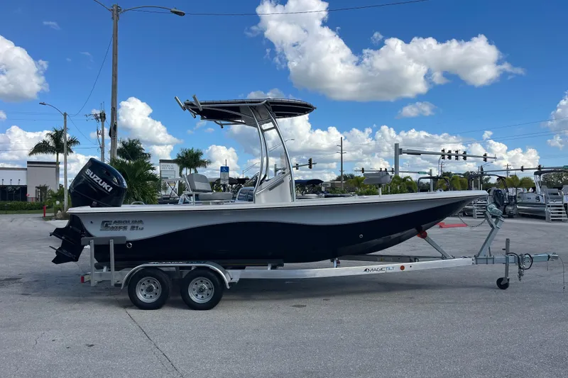 Slide: The Image of 2025 Carolina Skiff 21 LS boat on trailer, parked outdoors under a blue sky. - 25