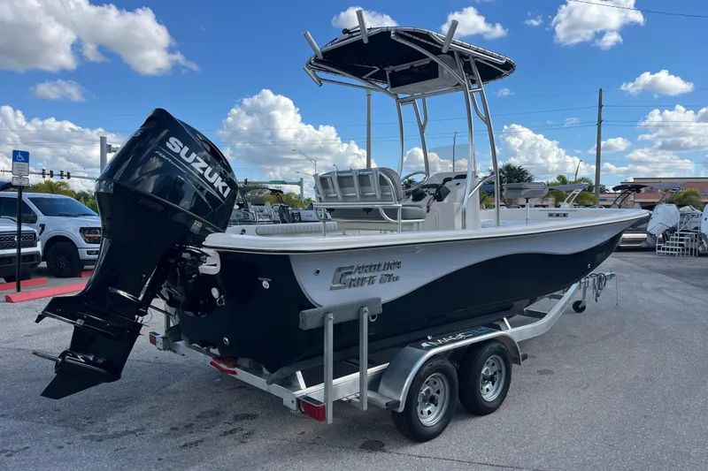 Slide: The Image of 2025 Carolina Skiff 21 LS boat with Suzuki engine on trailer, parked outdoors. - 26