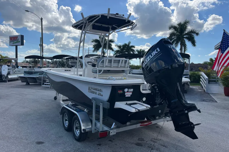Slide: The Image of 2025 Carolina Skiff 21 LS boat with Suzuki outboard motor on trailer, dealership background. - 28