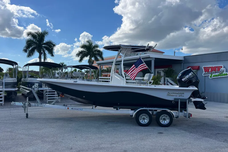 Slide: The Image of 2025 Carolina Skiff 21 LS boat on trailer, American flag, palm trees, dealership background. - 29