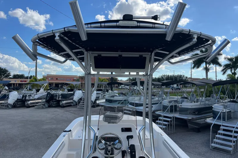 Slide: The Image of 2025 Carolina Skiff 21 LS boat with T-top and rod holders in a marina. - 31