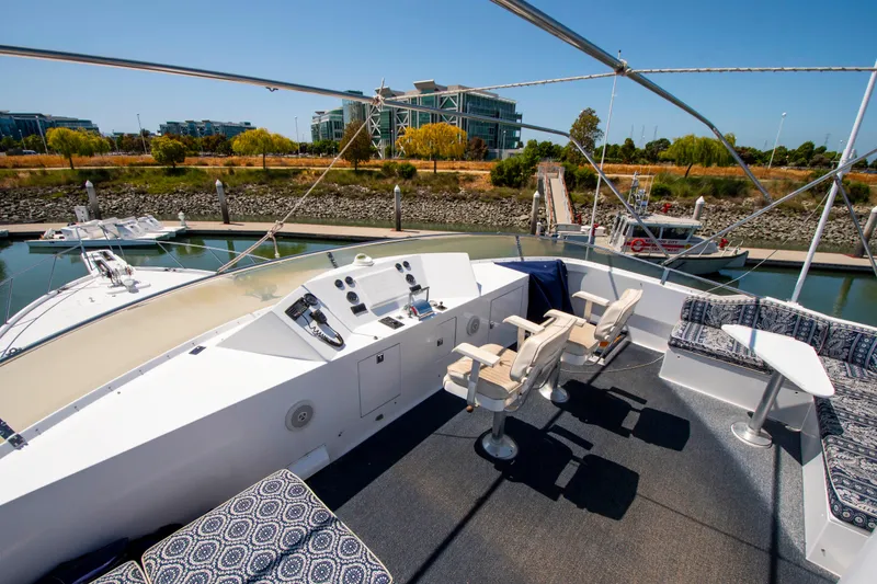 Slide: The Image of 1988 Knight & Carver Motoryacht deck with seating, helm, and marina view. - 10