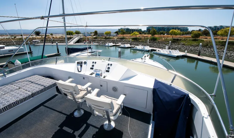 Slide: The Image of 1988 Knight & Carver Motoryacht, marina view, spacious deck with seating and controls. - 11