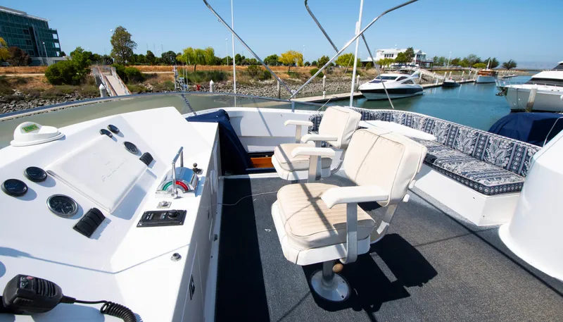 Slide: The Image of 1988 Knight & Carver Motoryacht deck with helm, chairs, and marina view. - 12