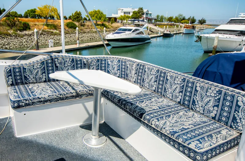 Slide: The Image of 1988 Knight & Carver Motoryacht with patterned seating, docked in a serene marina. - 13