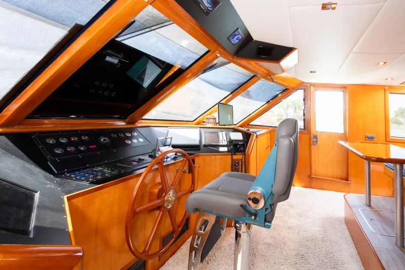 Slide: The Image of Luxurious 1988 Knight & Carver motoryacht helm with wooden steering wheel and modern controls. - 16