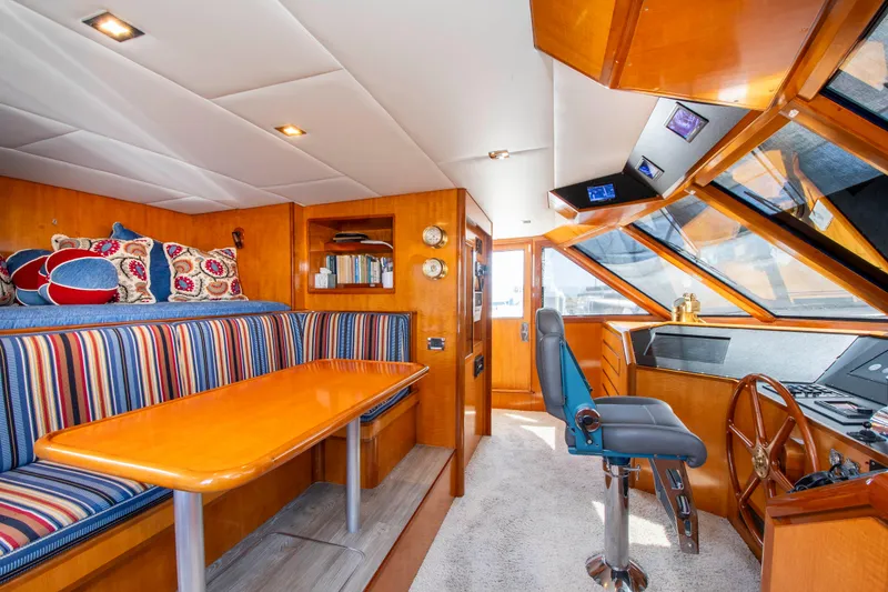 Slide: The Image of 1988 Knight & Carver Motoryacht interior with striped seating, wooden table, and helm station. - 17