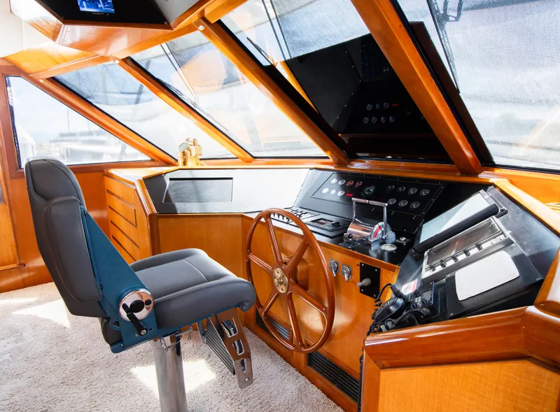 Slide: The Image of 1988 Knight & Carver Motoryacht helm with wooden steering wheel and modern controls. - 18