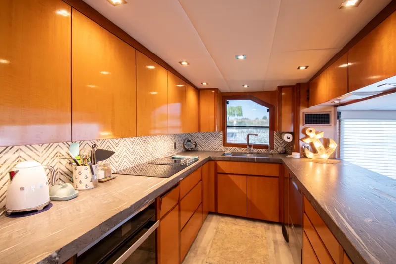 Slide: The Image of Luxurious 1988 Knight & Carver motoryacht kitchen with modern wood cabinetry and sleek countertops. - 26