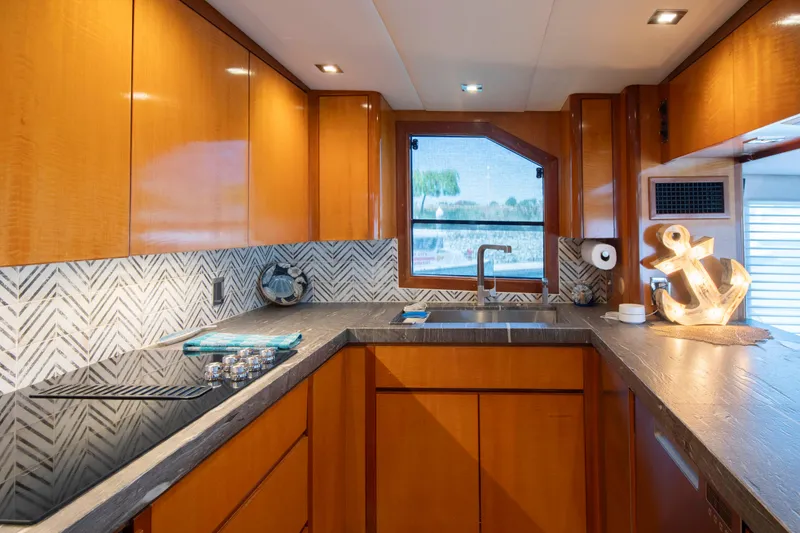 Slide: The Image of Luxurious 1988 Knight & Carver motoryacht kitchen with modern wood cabinetry and elegant countertops. - 27