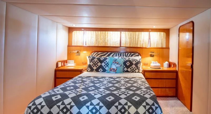 Slide: The Image of Luxurious 1988 Knight & Carver motoryacht bedroom with patterned bedding and wooden accents. - 29