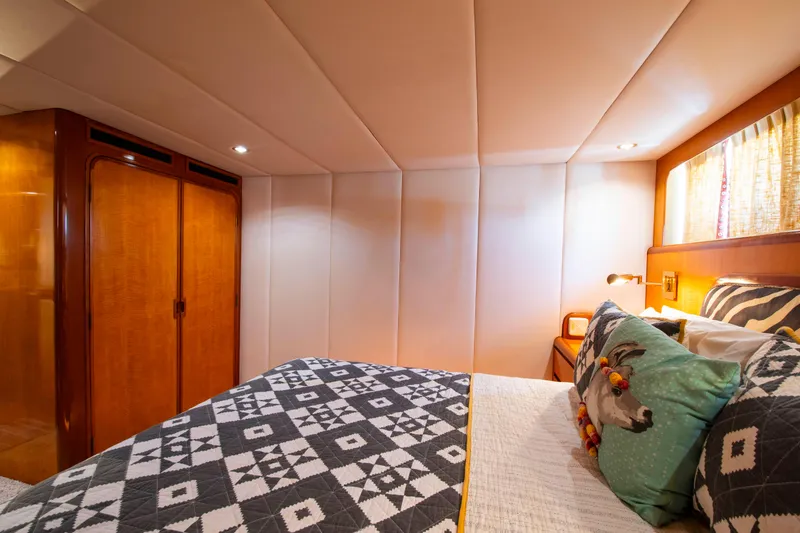 Slide: The Image of Luxurious 1988 Knight & Carver Motoryacht bedroom with patterned bedding and wooden accents. - 32
