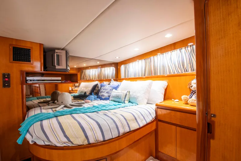Slide: The Image of Cozy bedroom interior of 1988 Knight & Carver Motoryacht with striped bedding and plush toys. - 41