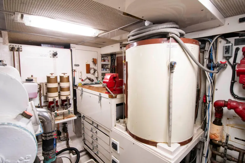 Slide: The Image of Engine room of a 1988 Knight & Carver Motoryacht, featuring machinery and storage units. - 44