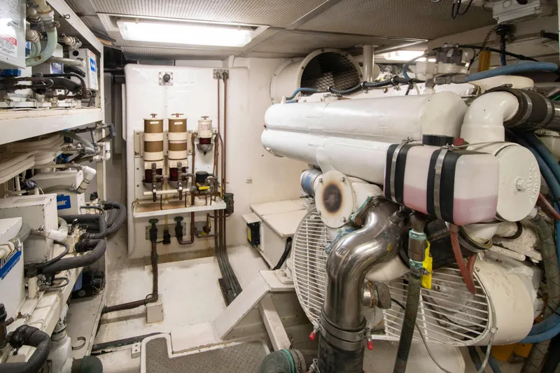 Slide: The Image of Engine room of a 1988 Knight & Carver Motoryacht, featuring complex machinery and piping systems. - 45