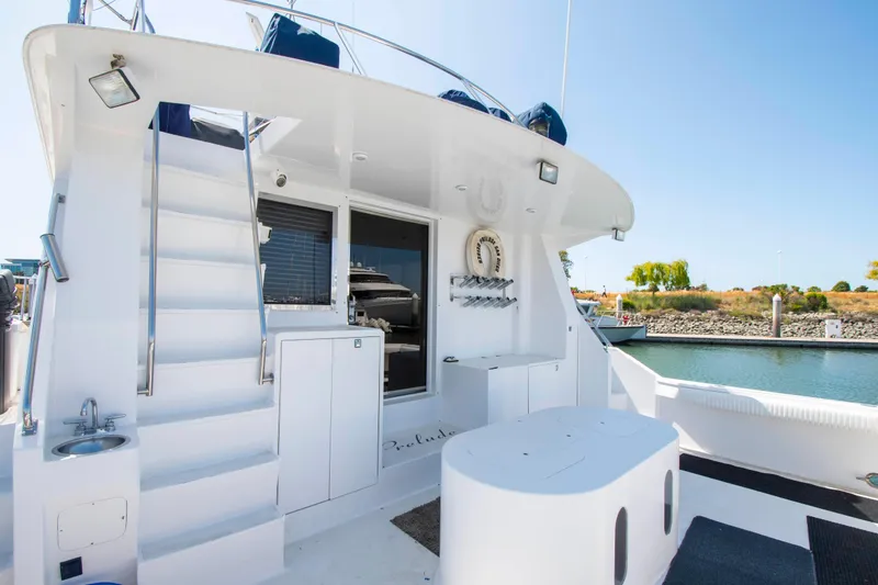 Slide: The Image of 1988 Knight & Carver Motoryacht deck with stairs, seating, and water view. - 5