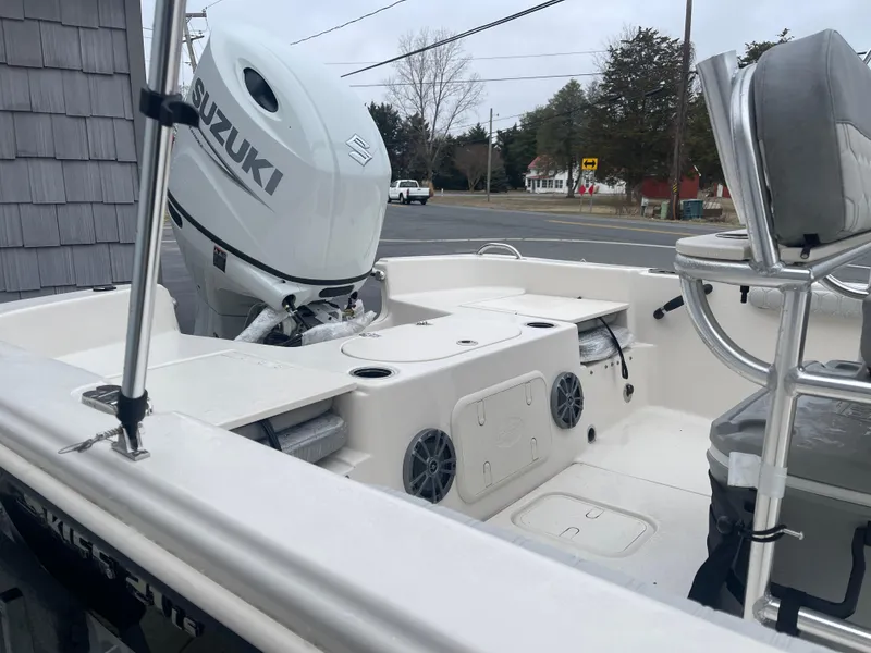 Slide: The Image of 2025 Carolina Skiff 21 LS boat with Suzuki outboard motor, parked near a road. - 10