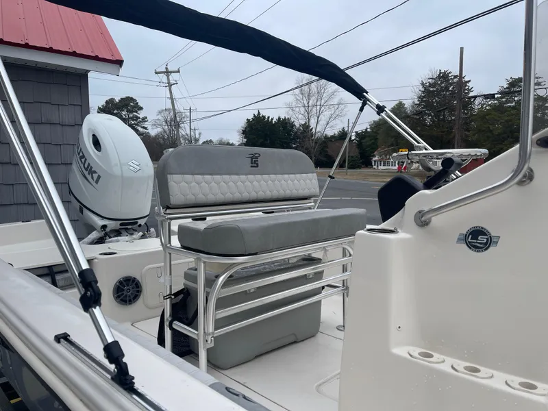 Slide: The Image of 2025 Carolina Skiff 21 LS boat interior with seating and Suzuki outboard motor. - 11