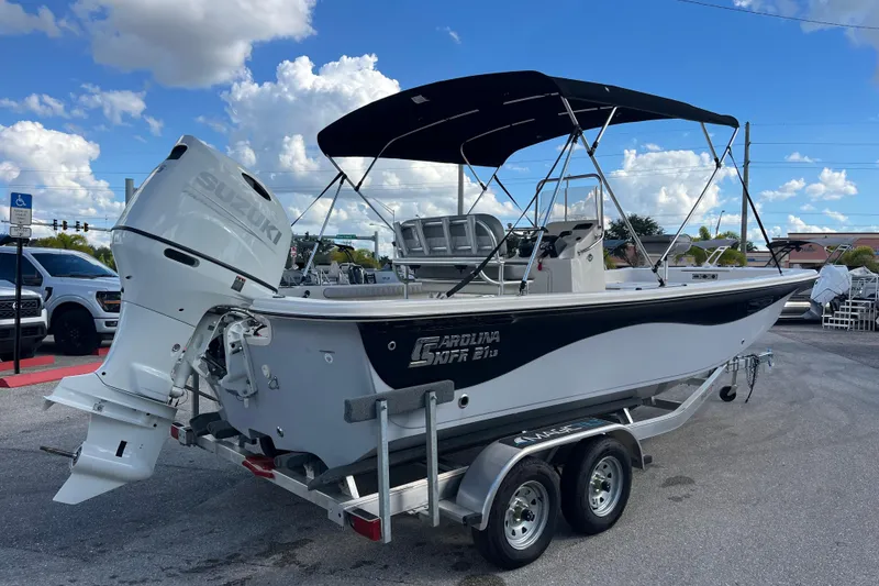 Slide: The Image of 2025 Carolina Skiff 21 LS boat on trailer, featuring Suzuki outboard motor and canopy. - 3