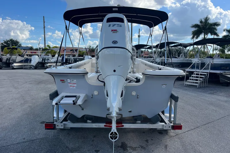 Slide: The Image of 2025 Carolina Skiff 21 LS boat with outboard motor on trailer, parked outdoors. - 4