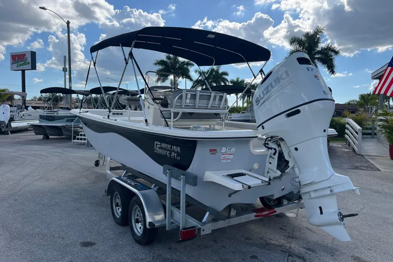Slide: The Image of 2025 Carolina Skiff 21 LS boat with Suzuki outboard motor on trailer, parked outdoors. - 5