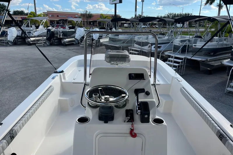 Slide: The Image of 2025 Carolina Skiff 21 LS boat interior with steering console, docked among other boats. - 8