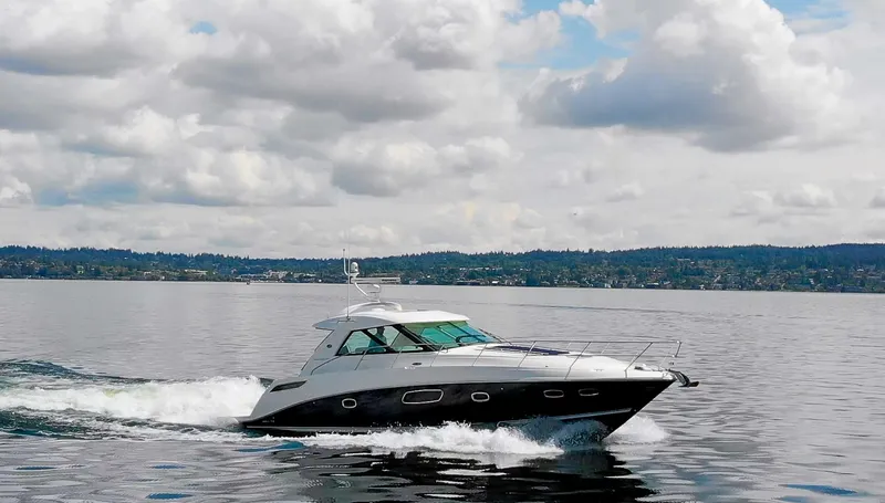Slide: The Image of 2011 Sea Ray 450 Sundancer cruising on a calm lake under a cloudy sky. - 46