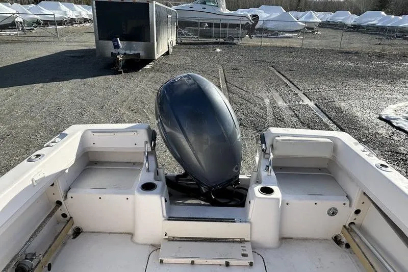 Slide: The Image of 1997 Grady-White Adventure 208 boat with outboard motor in a storage yard. - 4