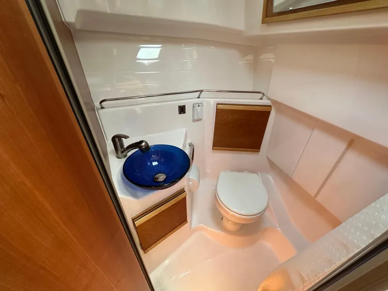 Slide: The Image of 2019 Cutwater C-28 boat bathroom with blue glass sink and compact toilet. - 22
