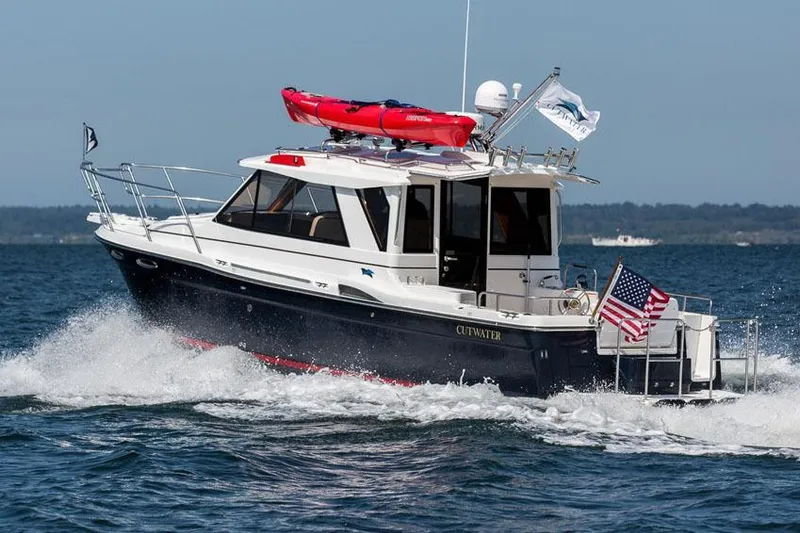 Slide: The Image of 2019 Cutwater C-28 boat cruising on water with American flag and kayak on top. - 41