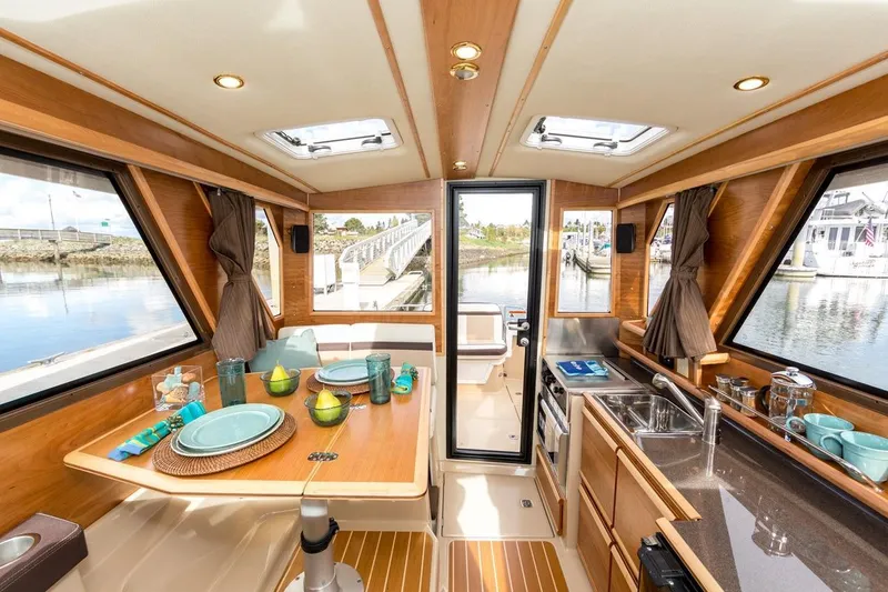 Slide: The Image of Interior of 2019 Cutwater C-28 boat with dining area and kitchenette, featuring wood finishes. - 46