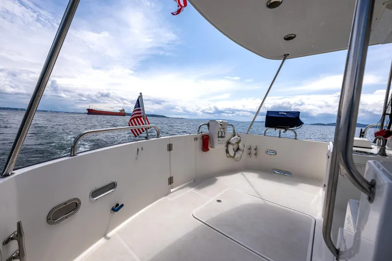 Slide: The Image of 2007 Nordic Tug 54 boat deck with ocean view and distant cargo ship. - 11