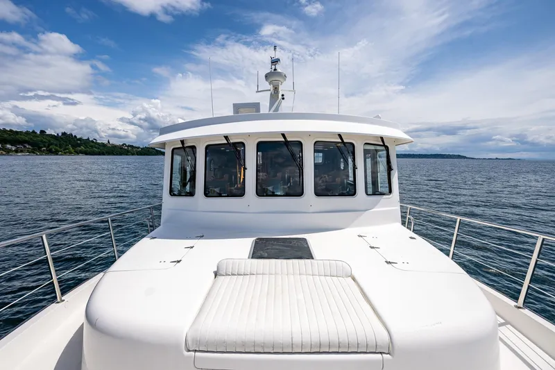 Slide: The Image of 2007 Nordic Tug 54 yacht on open water under a partly cloudy sky. - 18