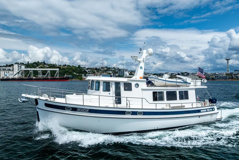Slide: The Image of 2007 Nordic Tug 54 cruising on water with cityscape and Space Needle in background. - 2