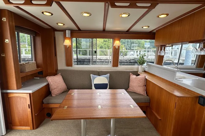 Slide: The Image of Cozy interior of 2007 Nordic Tug 54 with wooden dining area and large windows. - 24