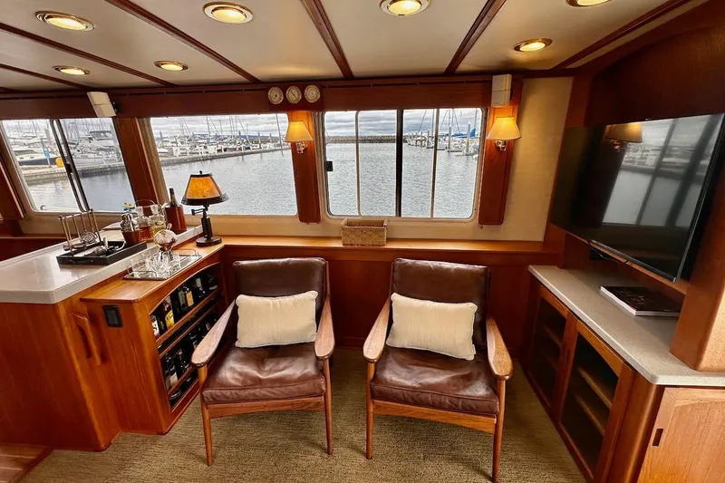 Slide: The Image of Luxurious interior of 2007 Nordic Tug 54 with leather chairs, bar, and marina view. - 26