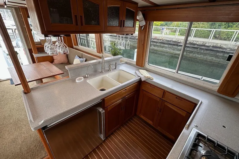 Slide: The Image of Luxurious 2007 Nordic Tug 54 galley with wooden cabinetry, dual sinks, and large windows. - 33