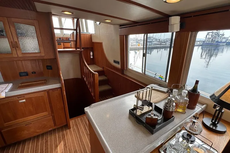 Slide: The Image of Interior of 2007 Nordic Tug 54 yacht with wooden cabinetry and bar setup. - 34