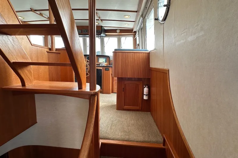 Slide: The Image of Interior of 2007 Nordic Tug 54, featuring wooden stairs and helm area. - 36