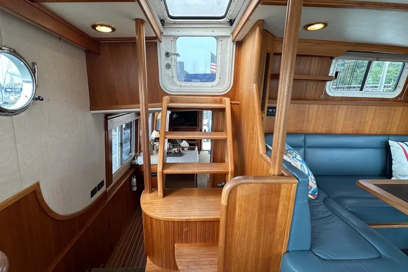 Slide: The Image of Interior of 2007 Nordic Tug 54, featuring wooden stairs and blue seating area. - 37